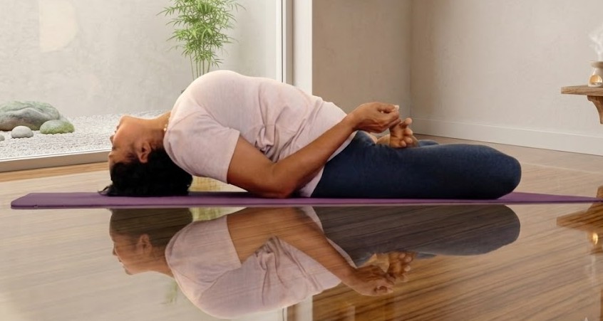 Practitioner in Matsyasana, the fish pose, arching the chest upward with the crown of the head toward the floor