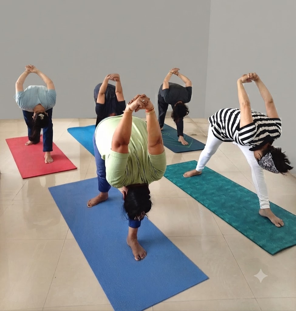 A teacher demonstrating a yoga pose in a bright studio